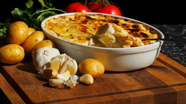Gratinované brambory v keramické misce s česnekem.
