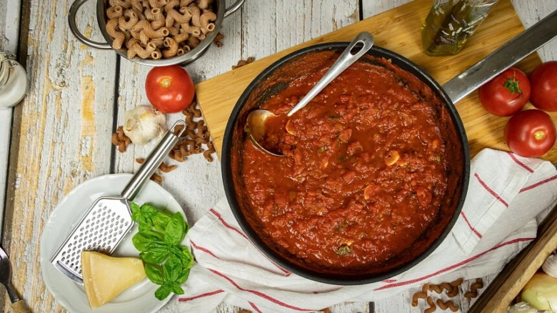 Připravená rajčatová omáčka s ingrediencemi na špagety.