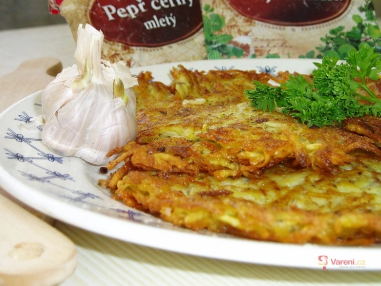 Zlatohnědé bramboráky s česnekem a petrželkou na talíři.