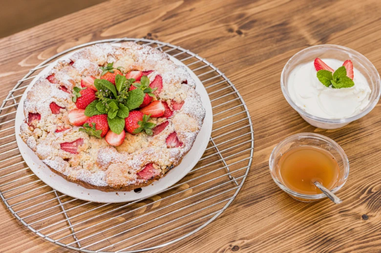 Strawberry crumble sýrová smetana medem na dřevěném stole.