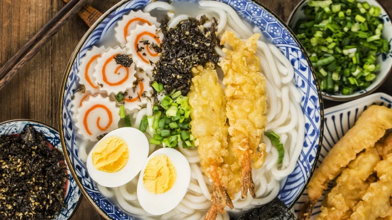 Miska s nudlemi udon se šupinami, vejcem a mořskými řasami.