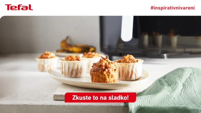 Svěží pečené muffiny na talíři vedle horkovzdušné trouby.