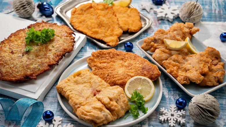 Různé typy obalených řízků s citronem na talířích.