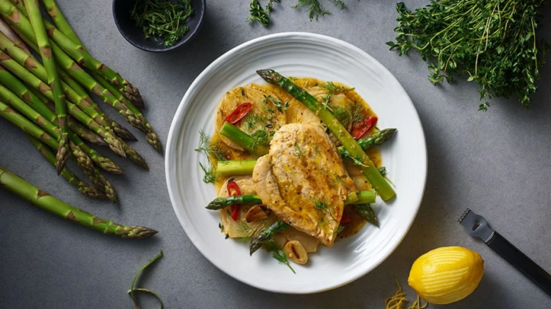 Kuřecí steak s omáčkou, špenátovými fazolemi a čerstvým citronem.