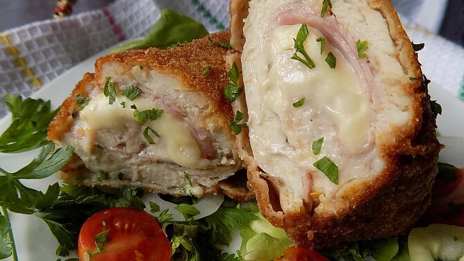 Složený kuřecí cordon bleu s uzeným a sýrem na talíři.