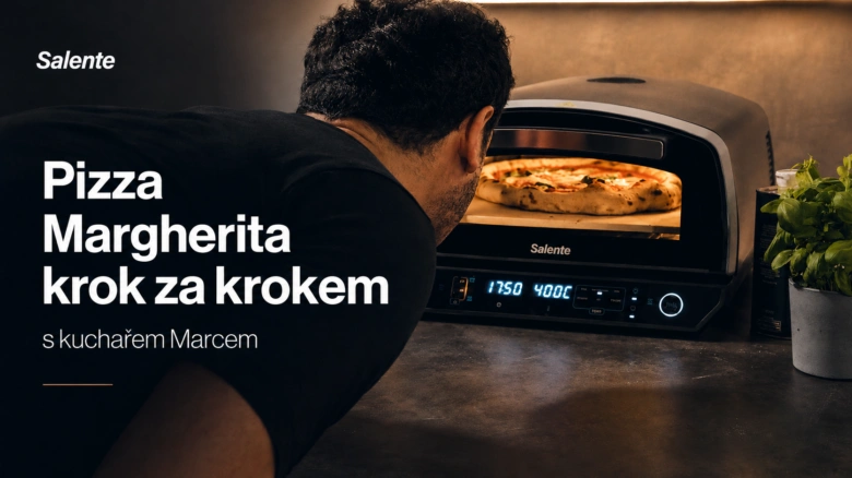 Muž peče pizzu Margheritu v troubě s čerstvou bazalkou.