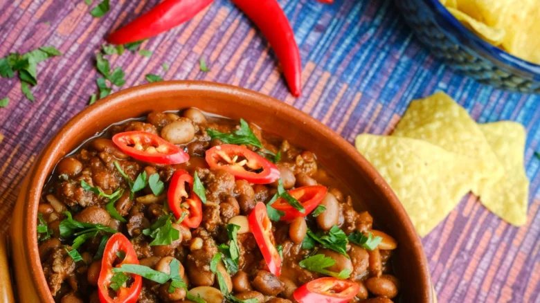 Mísa s chilli con carne ozdobená nakrájenou paprikou.