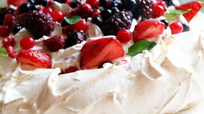 Pavlova dessert with berries and cream