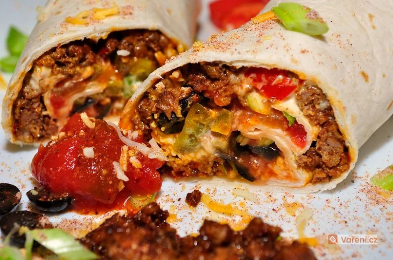 Překrojený burrito s mletým masem, zeleninou a sýrem.