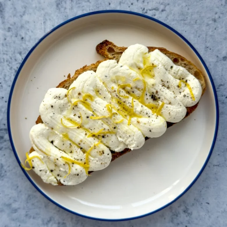Pomazánka z ricotty na toastu s citronovou kůrou.