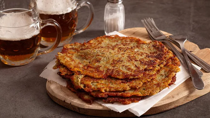 Skládané bramboráky s pivem na dřevěném podnosu.