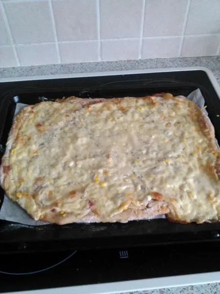 Hotová cottage pizza s rozetou na plechu.