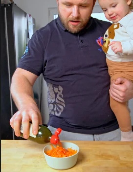 Muž nalévá zálivku na mrkev pro salát.