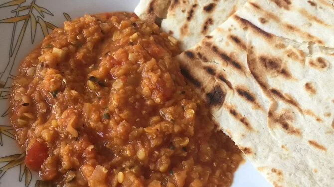 Indický dhal z červené čočky podávaný s chlebem naan.