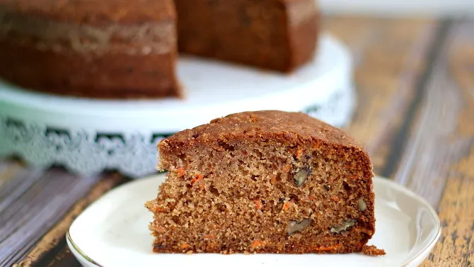 Slice of carrot cake with nuts and carrots visible inside th