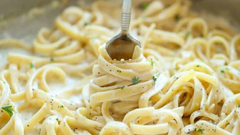 Fork s těstovinami v krémové omáčce se pepřem.