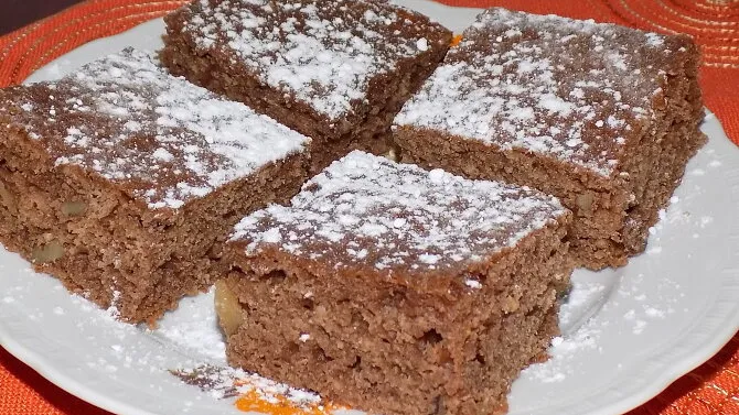 Čtyři kousky domácího perníku posypané cukrem na talíři.