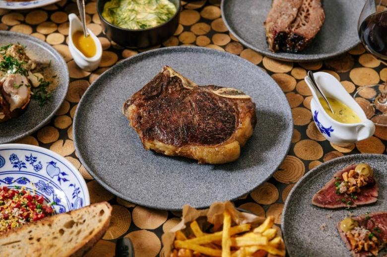 Grilovaný steak na talíři s přílohami pro recept.