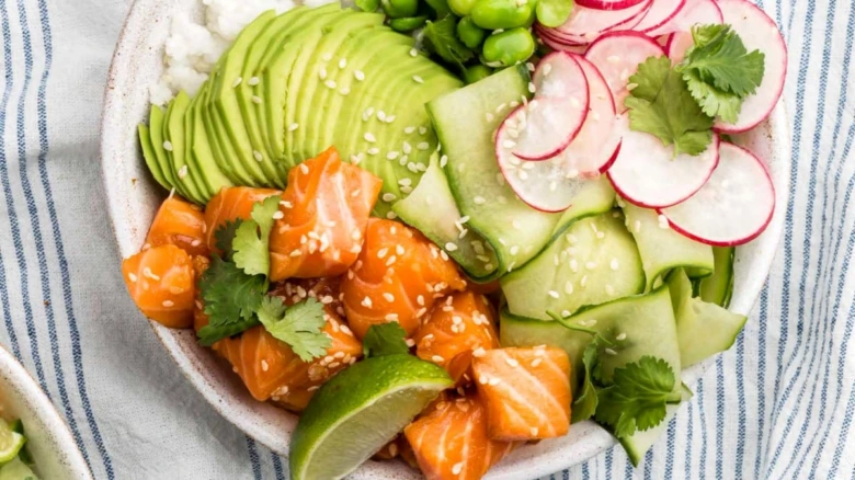 Poké bowl s lososem, avokádem a čerstvou zeleninou.