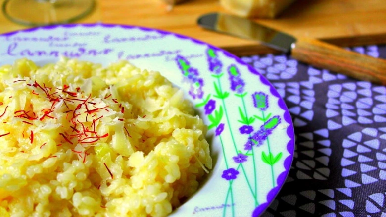 Příprava italského rizota s kurkumou, česnekem a parmazánem.