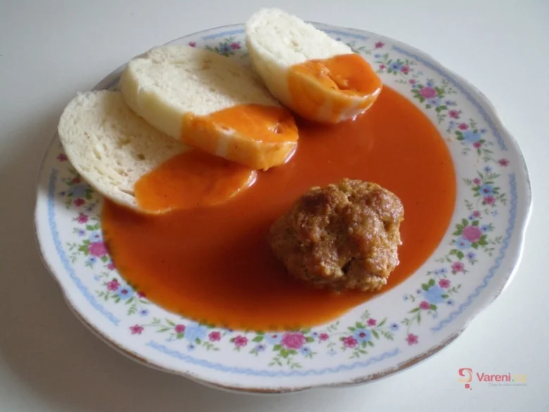 Maso kulička v rajské omáčce s bílým chlebem na talíři.