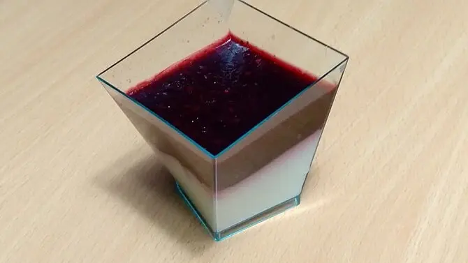 Dokončený italský dezert panna cotta s vrstvou ovocné polevy.