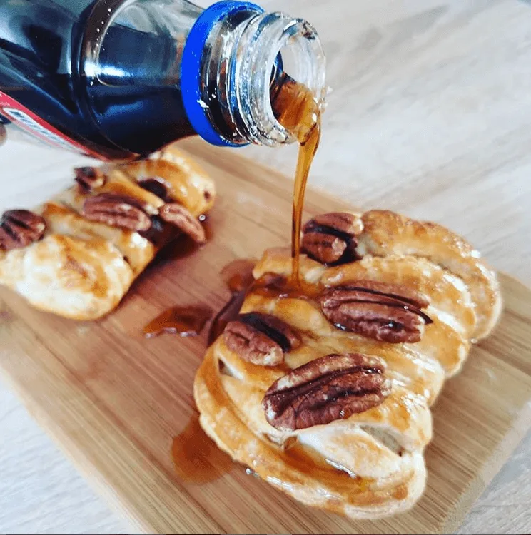 Zlatohnědý pletenec s pekanovými oříšky, na který se nalévá sirup.