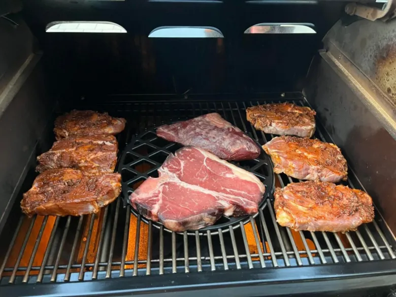 Kusky masa na mřížce v otevřeném grilu připravené k pečení.