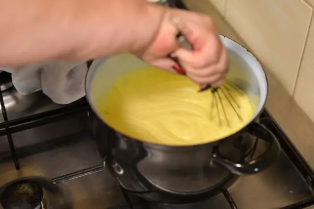 Whisking yellow sauce in pot