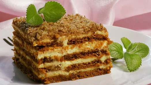 Kus dezertu z mascarpone s vrstvami krému na bílém talíři.