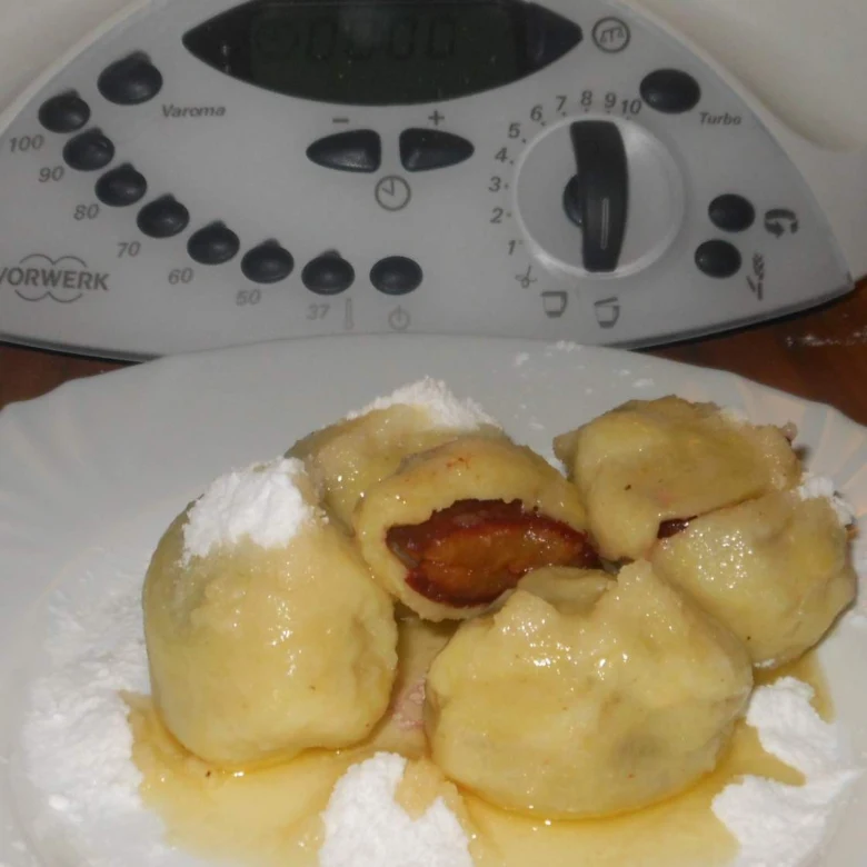 Parní bramborové knedlíky se švestkami posypané moučkovým cukrem.