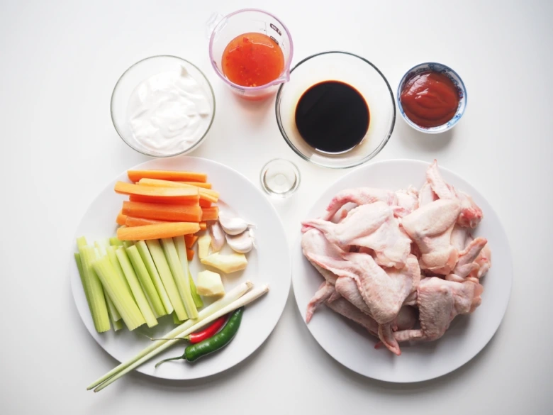 Surová kuřecí křídla s ingrediencemi na marinádu.
