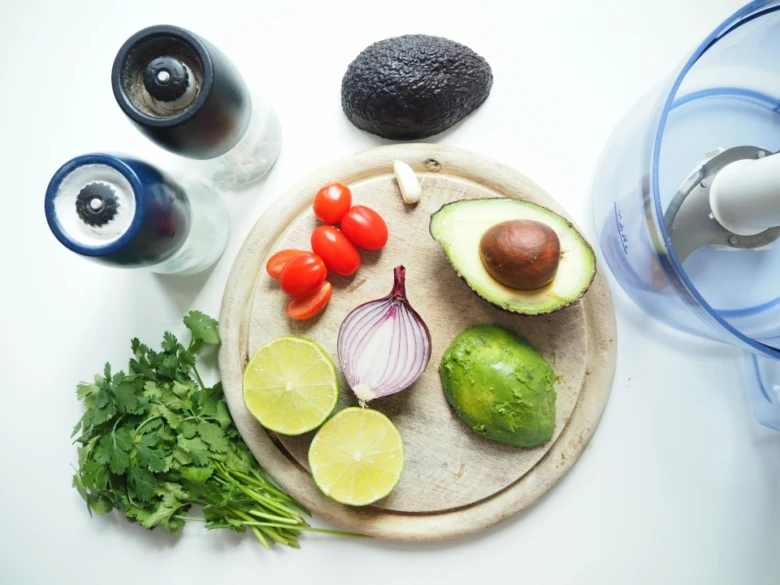 Suroviny na guacamole: avokádo, rajčata, citrony, celerina a cibule.