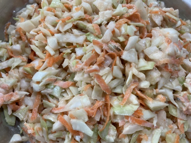 Příprava coleslaw salátu s bílou kapustou a mrkví.