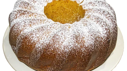 Bábovka posypaná moučkovým cukrem s žlutou náplní.