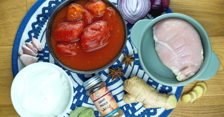 Suroviny pro kuřecí tikka masalu: kuře, rajčata, koření.