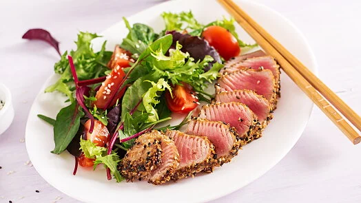 Opečený steak z tuňáka podaný s čerstvou salátovou směsí.