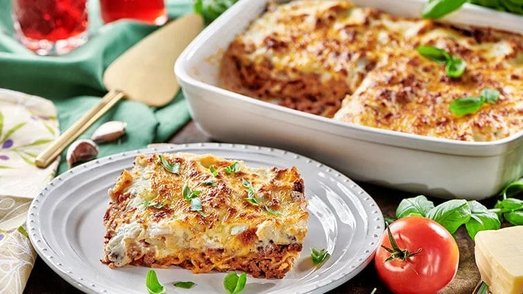 Kousek pečené lasagne z mletého masa s bazalkou.
