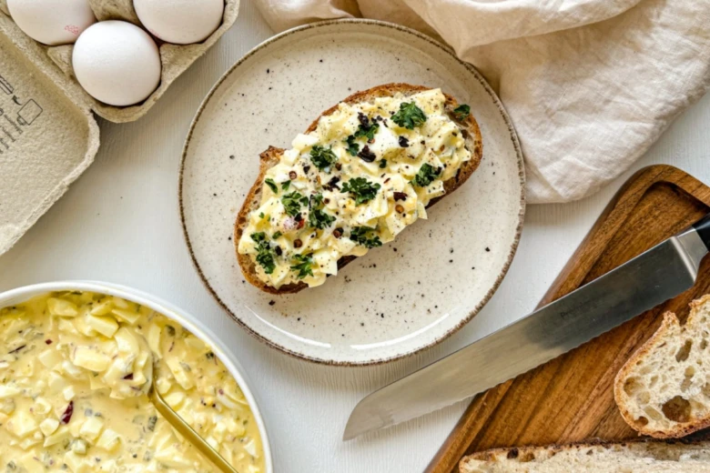 Tvarohová vajíčková pomazánka na toastu s bylinkami.