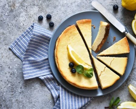 Pečený cheesecake s citronem a borůvkami na talíři.
