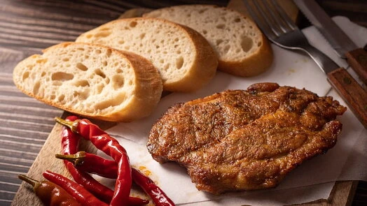 Grilovaná krkovička s chlebem a červenými chilli papričkami.