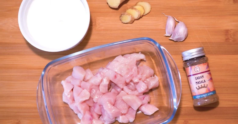 Surové kuřecí maso s kořením pro indické tikka masala.