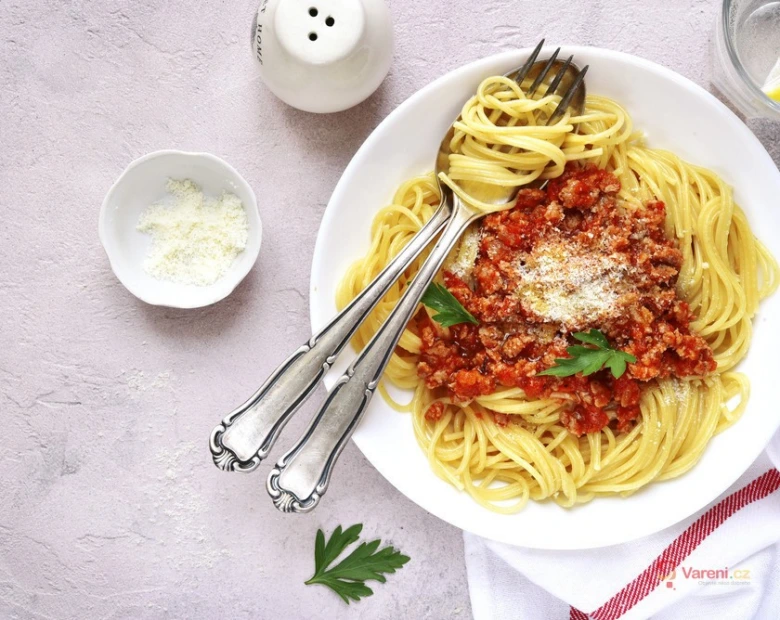 Pasta s boloňskou omáčkou na talíři se syrovátkem.