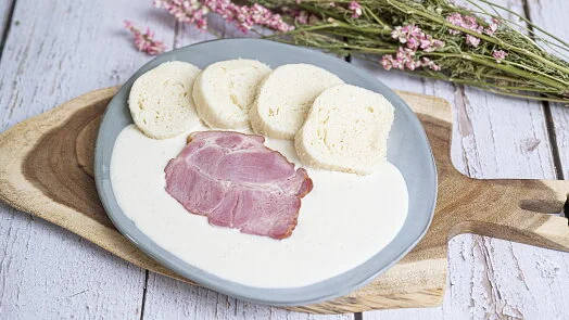 Připravené šunkofleky s bílým omáčkou na talíři.