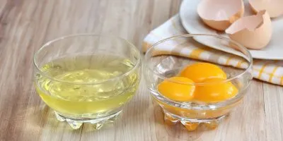Oddělené vaječné bílky a žloutky ve sklenicích.