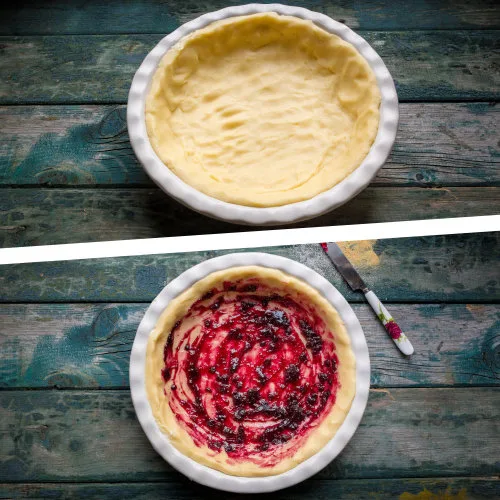 Hotový tvarohový cheesecake s ovocným vrstvou v bílém pekáči.