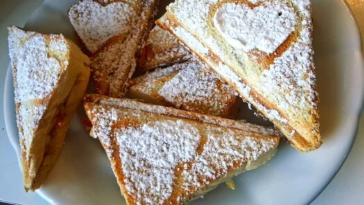 Trianguly žemlovek posypané moučkovým cukrem na talíři.