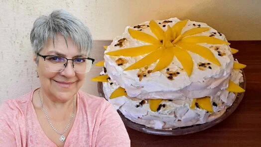 Žena stojí vedle hotového dortu Pavlovy s mangem.