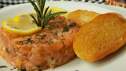 Gravlax losos s citronem, rozmarýnem a kousky chleba.