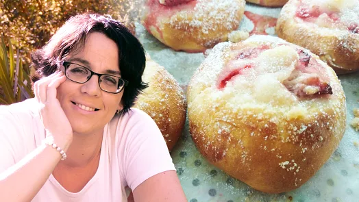 Žena se usmívá vedle svatebních koláčků s ovocem.